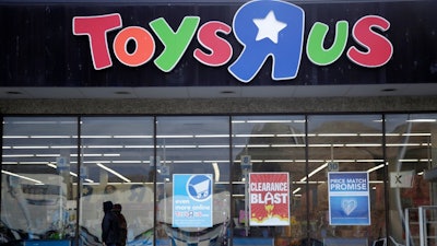 This Jan. 24, 2018, file photo shows a person walking near the entrance to a Toys R Us store, in Wayne, N.J. Toys R Us's management has told its employees that it will sell or close all of its U.S. stores. That's according to a toy industry analyst who spoke to several employees who were on the call Wednesday, March 14, 2018. Jim Silver, a toy industry expert, says Toys R Us's CEO told employees the plan is to liquidate all of its U.S. stores and after that, it could do a deal with its Canadian operation to run some of its U.S. stores. The company declined to comment.