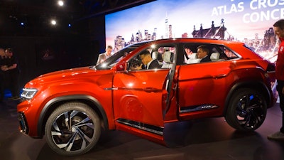 Journalists look at Volkswagen's five-passenger SUV concept at the New York Auto Show, Tuesday, March 27, 2018. The vehicle will be designed and engineered for the American market and Volkswagen will construct it at its plant in Chattanooga, Tenn.