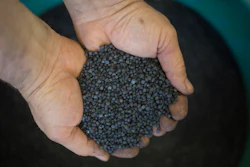 In this Tuesday, March 13, 2018 photo, a worker holds bio-based thermoplastic composite made from substantially unsorted municipal solid waste material in the UBQ factory in Kibbutz Zeelim. Israeli start-up UBQ says its innovative method to convert garbage into plastics, five years in the making, will revolutionize waste management worldwide and make landfills obsolete.