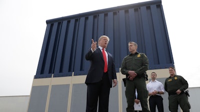 President Donald Trump speaks during a tours as he reviews border wall prototypes, Tuesday, March 13, 2018, in San Diego, as Rodney Scott, the Border Patrol's San Diego sector chief, listens.