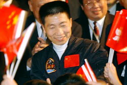 In this Oct. 31, 2003, file photo, school children wave Chinese and Hong Kong flags as they welcome China's first astronaut Yang Liwei, center, to Hong Kong's Government House for an official reception hosted by Hong Kong's Chief Executive Tung Chee-hwa, shortly after arriving for a five-day visit to the territory. China says it plans to begin recruiting civilian astronauts for its military-backed space program and increase the number of crewed missions to around two a year. Yang told reporters Saturday, March 3, 2018, new astronauts will include maintenance engineers and payload specialists as well as pilots.