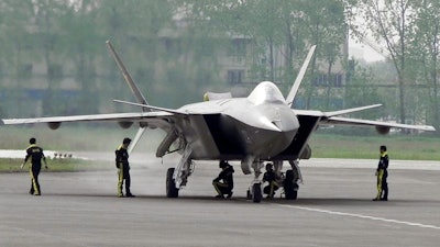 In this April 17, 2011 file photo, Chinese ground crew members inspect a J-20 stealth fighter in Chengdu, in southwest China's Sichuan province. China's defense budget will rise 8 percent to 1.1 trillion yuan ($173 billion) this year as the country is preparing to launch its second aircraft carrier, integrating stealth fighters into its air force and fielding an array of advanced missiles able to attack air and sea targets at vast distances, according to a report released Monday, March 5, 2018.