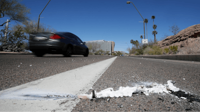 A vehicle goes by the scene of Sunday's fatality where a pedestrian was stuck by an Uber vehicle in autonomous mode, in Tempe, Ariz., Monday, March 19, 2018. A self-driving Uber SUV struck and killed the woman in suburban Phoenix in the first death involving a fully autonomous test vehicle.