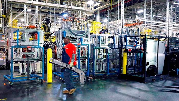 In this March 19, 2018, file photo a line technician walks past window panels near the NV Commercial Van assembly line at the Nissan Canton Assembly Plant, in Canton, Miss. On Tuesday, April 17, the Federal Reserve reports on U.S. industrial production for March.