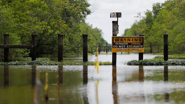 In this Friday, April 27, 2018 photo, a sign and barrier for an existing pipeline is displayed on Bayou Sorrel in the Atchafalaya River Basin in Louisiana. A company building a crude oil pipeline is asking a federal appeals court to throw out a judge's order that had suspended construction work in the environmentally fragile swamp. A three-judge panel of the 5th U.S. Circuit Court of Appeals is scheduled to hear arguments Monday, April 30, by attorneys for Bayou Bridge Pipeline LLC, federal regulators and environmental groups opposed to the project. In February, a judge temporarily stopped all pipeline construction work in the Atchafalaya Basin.