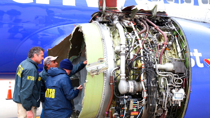 National Transportation Safety Board investigators examine damage to the engine of the Southwest Airlines plane that made an emergency landing at Philadelphia International Airport in Philadelphia on Tuesday, April 17, 2018. The Southwest Airlines jet blew the engine at 32,000 feet and got hit by shrapnel that smashed a window, setting off a desperate scramble by passengers to save a woman from getting sucked out. She later died, and seven others were injured.