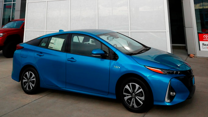 An unsold 2018 Prius sits on a Toyota dealer's lot in the south Denver suburb of Englewood, Colo. Toyota says it will start equipping models with technology to talk to other vehicles starting in 2021, as it tries to push safety communications forward.