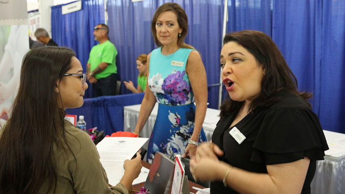 In this March 28, 2018, photo, Roxy Creed, left, speaks to Mandara Spa Operations Manager Lena Andrade about employment opportunities at a job fair in Honolulu. Recently released numbers show Hawaii boasts the United States' lowest jobless rate, at 2.1 percent. But experts say the figure is masking underlying problems.