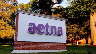 In this June 1, 2017, file photo, a sign stands on the campus of the Aetna headquarters in Hartford, Conn. Some major health insurers plan to take a little sting out of prescription drug prices by giving customers rebates at the pharmacy counter, and they could spark a trend. Aetna and UnitedHealthcare both say they will begin passing rebates they get from drugmakers along to some of their customers starting next year.