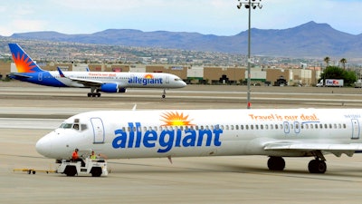 In this May 9, 2013, file photo, two Allegiant Air jets taxi at McCarran International Airport in Las Vegas. Shares of Allegiant Air’s parent company are tumbling in Monday, April 16, 2018, premarket trading following a “60 Minutes” investigation that expressed serious safety concerns about the airline.