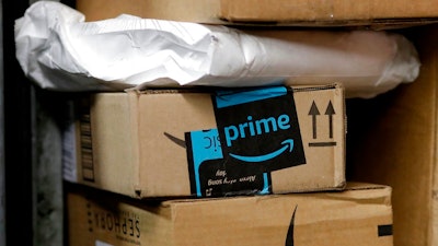 In this May 9, 2017, file photo, a package from Amazon Prime is loaded for delivery in New York. Last year, the online retailer introduced a system for letting people delivering packages into customers’ homes. Now, it’s their cars. GM says more than 7 million owners of Chevrolet, Buick, GMC and Cadillac vehicles are eligible for Amazon’s new Amazon Key In-car delivery service.