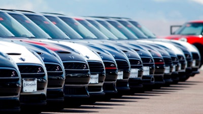 In this Friday, March 30, 2018, photograph, a line of unsold 2018 Cooper Clubmen sit in a long row at a Mini dealership in Highlands Ranch, Colo. U.S. auto sales grew 6.3 percent in March on rising sales of SUVs and pickup trucks.