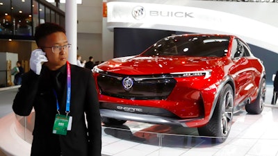 A security person stands near a Buick concept SUV during the start of the Auto China 2018 in Beijing, China, Wednesday, April 25, 2018. Volkswagen and Nissan have unveiled electric cars designed for China at the Beijing auto show that highlights the growing importance of Chinese buyers for a technology seen as a key part of the global industry's future.