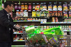 A man pushes a shopping cart past a display of nuts imported from the United States and other countries at a supermarket in Beijing, Monday, April 2, 2018. China raised import duties on a $3 billion list of U.S. pork, fruit and other products Monday in an escalating tariff dispute with President Donald Trump that companies worry might depress global commerce.