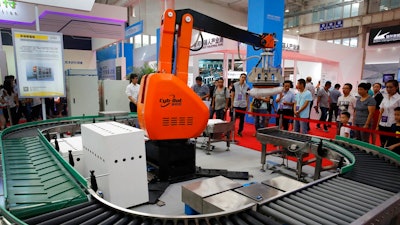 In this Aug. 23, 2017, photo, visitors watch a Chinese-made industrial robot demonstrating on lifting goods during the World Robot Conference at the Yichuang International Conference and Exhibition Centre in Beijing. China On Wednesday, April 4, 2018 vowed to take measures of the 'same strength' in response to a proposed U.S. tariff hike on $50 billion worth of Chinese goods in a spiraling dispute over technology policy that has fueled fears it might set back a global economic recovery. The Commerce Ministry said it would immediately challenge the U.S. move in the World Trade Organization.