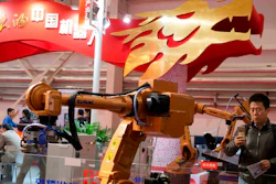 In this Oct. 21, 2016 file photo, visitors look at industrial robots displayed beneath the words that read 'Chinese Robots' during the World Robot Conference in Beijing. U.S. officials have a name for their frustration with Beijing’s technology ambitions: ‘Made in China 2025.’ President Donald Trump’s government says China’s plan to create global competitors in fields from information technology to electric cars to pharmaceuticals is an example of policies that prompted Trump’s threat to hike tariffs on $50 billion of Chinese goods. They say China’s tactics include improperly subsidizing local and pressuring foreign competitors to hand over technology.