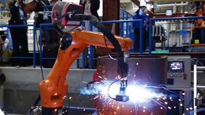 Shimizu Corp.'s Robo-Welder is demonstrated during a press tour to the major Japanese construction company's robot laboratory in Tokyo, Monday, April 23, 2018. The Robo-Welder has a robotic arm that uses laser shape measurement to determine the contours of a groove, or channel, on a steel column to be welded. Shimizu showed several robots that can weld and bolt, being developed for construction sites for safety for workers.