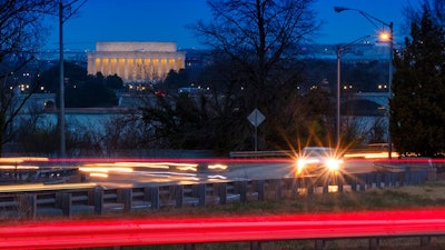 Traffic streaks along U.S. Highway 50 early in the morning, Friday, March 30, 2018 across the Potomac River from Washington in Arlingotn, Va. The Trump administration is expected to announce that it will roll back automobile gas mileage and pollution standards that were approved during the Obama administration. Current regulations call for new vehicles to get 36 miles per gallon in real-world driving by 2025. That's about 10 mpg over the existing standard. Automakers say they'll have trouble reaching the new standards because people want bigger vehicles. But environmental groups say the technology exists for automakers to comply.