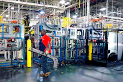 In this March 19, 2018, file photo a line technician walks past window panels near the NV Commercial Van assembly line at the Nissan Canton Assembly Plant, in Canton, Miss. On Tuesday, April 17, the Federal Reserve reports on U.S. industrial production for March.
