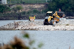 In this file photo workers are shown at San Jacinto River Waste Pits near the Interstate 10 bridge over the river in Channelview, Texas.