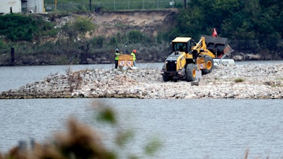 In this file photo workers are shown at San Jacinto River Waste Pits near the Interstate 10 bridge over the river in Channelview, Texas.