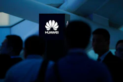 In this May 26, 2016, photo, attendees stand near a pillar with the Huawei logo during a launch event for the Huawei Matebook in Beijing. As trade disputes simmer, Chinese telecommunications giant Huawei, the No. 3 smartphone brand, is shifting its growth efforts toward Europe and Asia in the face of mounting obstacles in the U.S. market.