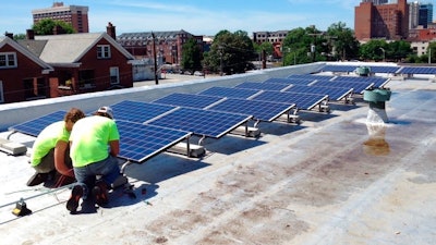 In this June 3, 2015 photo made available by NC WARN, workers install a solar power system on the roof of Faith Community Church in Greensboro, NC. The installation and the electricity the panels generated prompted a dispute being considered by the North Carolina Supreme Court that will be heard on Tuesday, April 17, 2018. State utilities regulators have ruled the group that funded the $20,000 cost of the solar panels violated state law protecting regulated monopoly electric utilities was illegally producing electricity 'for the public.' The group, NC WARN, says it was an allowable private power agreement with the church alone.