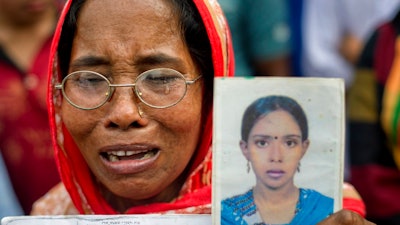 A Bangladeshi woman cries holding a portrait of her daughter who was a victim of the Rana Plaza garment factory collapse, on the fifth anniversary of the accident in Savar, near Dhaka, Bangladesh, Tuesday, April 24, 2018. The tragedy killed 1,134 people, many of them young women supporting extended families, and injured more than 2,500.
