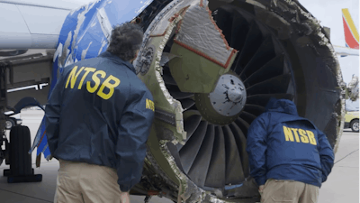 National Transportation Safety Board investigators examine damage to the engine of the Southwest Airlines plane that made an emergency landing at Philadelphia International Airport in Philadelphia on Tuesday, April 17, 2018.