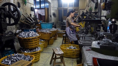 In this Wednesday, Oct. 21, 2015 file photo, a worker manufactures metal parts in an auto parts factory in Rui'an near Wenzhou city in eastern China's Zhejiang province. Chinese exporters of goods from electronics to motorcycle parts are scrambling to insulate themselves from U.S. President Donald Trump’s proposed tariff hike. They are weighing plans to rush shipments to American customers ahead of the increase, raise prices or find other markets. Some are looking at shipping goods through other countries to hide their Chinese origin.