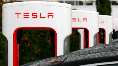 In this May 14, 2015, file photo, Tesla charging stations are shown outside of the Tesla factory in Fremont, Calif. California workplace safety regulators say they are investigating two incidents at automaker Tesla’s factory. The investigations follow a report by the Center for Investigative Reporting cataloguing a series of workplace injuries at Tesla. Tesla said the center incorrectly counted injuries that occurred away from the factory in Fremont.