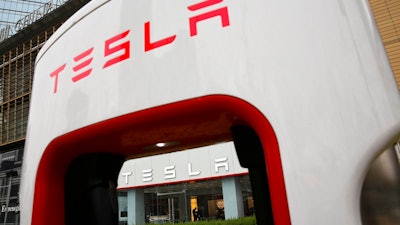 A sales person stands inside a Tesla electric vehicle showroom in Beijing, Thursday, April 5, 2018. The United States and China, the world's two largest economies, have roiled financial markets and fueled fears of a protracted trade war by threatening tariffs this week on each other's goods. The United States on Tuesday said it would impose 25 percent duties on $50 billion of imports from China, and China quickly retaliated by listing $50 billion of products that it could hit with its own 25 percent tariffs.