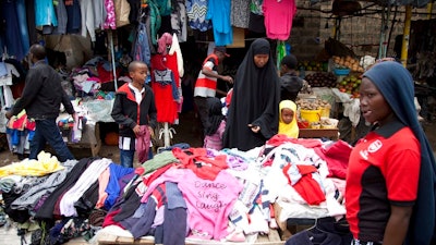 In this Sunday April 8, 2018 people look through piles of second hand clothes at a roadside stall, in Nairobi, Kenya. The used clothes cast off by Americans and sold in bulk in African nations, a multimillion-dollar business, have been blamed in part for undermining local textile industries.