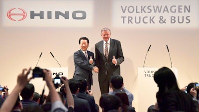 Andreas Renschler, right, a board member at Volkswagen AG and CEO of Volkswagen Truck & Bus, and Hino Motors President and Chief Executive Yoshio Shimo, left, pose for the media during a press conference in Tokyo, Thursday, April 12, 2018. Hino Motors, Toyota Motor Corp.'s group truck manufacturer, and Volkswagen Truck & Bus of Germany agreed Thursday to work together in a partnership on technologies like hybrids, electric cars, autonomous driving and connectivity.