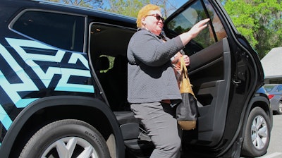 In this photo taken March 7, 2018 shows Cinzhasha Farmer, who is blind, exiting a vehicle equipped with software meant to help the visually impaired interact with self-driving cars in Ocala, Fla. The 41-year-old was eager to participate in the study so she can one day drive without relying on others.'It's one of my goals and I don't know how I'll ever accomplish it, but that car may do it,' she said with a smile.
