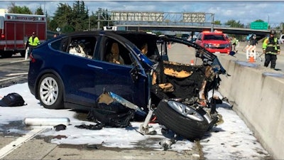 In this March 23, 2018, file photo provided by KTVU, emergency personnel work at the scene where a Tesla electric SUV crashed into a barrier on U.S. Highway 101 in Mountain View, Calif. Federal safety investigators have booted electric car maker Tesla Inc. from the group investigating a fatal crash in California that involved an SUV operating with the company's Autopilot system. The National Transportation Safety Board said Thursday, April 12, it removed Tesla as a party to the investigation after the company prematurely made information public.