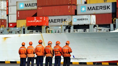 Chinese workers stand in front of a loaded cargo ship docked at a port in Qingdao in east China's Shandong province, Sunday, April 8, 2018. Amid falling markets, President Donald Trump's new economic adviser, Larry Kudlow, says there is no trade war between the U.S. and China. Another administration official, Treasury Secretary Steve Mnuchin, takes a different tack, saying he's 'cautiously optimistic' that before any threatened tariffs go into place the two nations will reach an agreement. Global financial markets have fallen sharply as the world's two biggest economies square off.