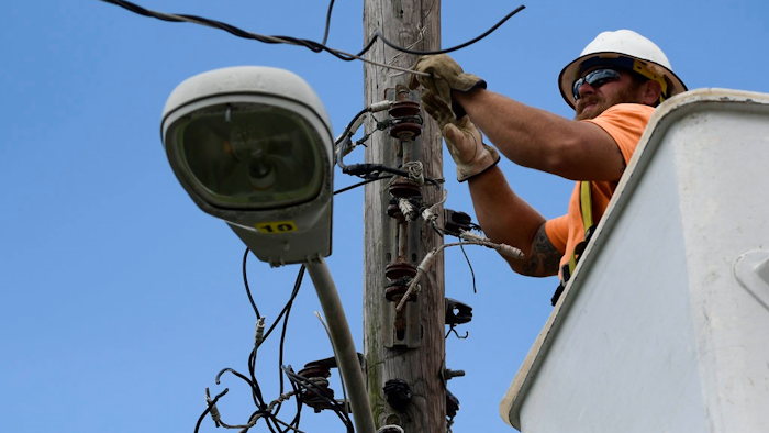 In this May 16, 2018 photo, a worker from the Cobra Energy Company, contracted by the Army Corps of Engineers, installs power lines in the Barrio Martorel area of Yabucoa, a town where many continue without power in Puerto Rico. A group of Corps officials plans to remain in Puerto Rico for several weeks to demobilize contractors and hand logistic operations back to FEMA and PREPA.