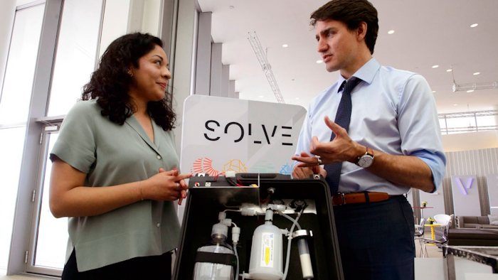 Prime Minister Justin Trudeau talks with Mariana Matus about her wastewater purification technology while visiting the MIT Media Lab and the Innovation Exhibition at Massachusetts Institute of Technology (MIT) in Boston on Friday, May 18, 2018.