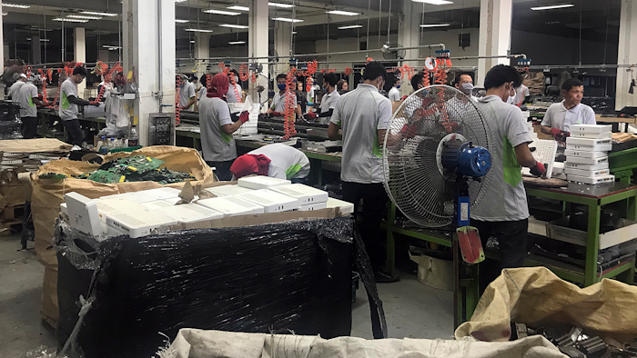 In this photo taken Thursday, May 24, 2018, and released by the Royal Thai Police, factory workers process electronic waste in Lat Krabang, outside Bangkok, Thailand. Police have raided several factories near Bangkok that allegedly were processing illegally imported electronic waste in a sign that China’s crackdown on waste recycling is pushing such operations offshore.