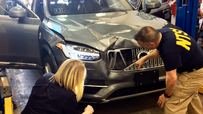 In this March 20, 2018, file photo provided by the National Transportation Safety Board, investigators examine a driverless Uber SUV that fatally struck a woman in Tempe, Ariz. Uber announced Wednesday, May 23, that it is pulling its self-driving cars out of Arizona, a reversal triggered by the recent death of woman who was run over by one of the ride-hailing service's robotic vehicles while crossing a darkened street in a Phoenix suburb.
