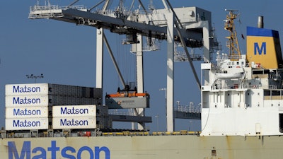 In this Dec. 13, 2017 file photo, a container ship is unloaded at the Port of Oakland in Oakland, Calif. Record exports trimmed the U.S. trade deficit in March 2018, the first drop in seven months in a massive gap that President Donald Trump is determined to shrink with an aggressive America First policy.