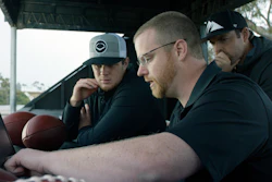 In this April 19, 2018, photo provided by Wilson Sporting Goods, quarterback Sam Darnold, left, and his mentor, former quarterback Jordan Palmer, right, look on as Wilson Labs engineer Dan Hare explains data gathered from throwing a football using the Wilson Connected Football System, at San Clemente High School in San Clemente, Calif. Darnold, the New York Jets rookie quarterback, was at his old stomping grounds in California last month tossing 'smart' footballs equipped with computer chips with Palmer, that were calculating his every throw.