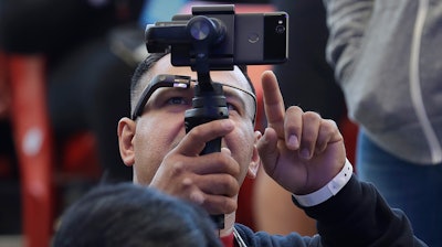 Developer Jesus Suarez wears Google Glass glasses while looking at his phone before the start of the keynote address at the Google I/O conference in Mountain View, Calif., Tuesday, May 8, 2018.