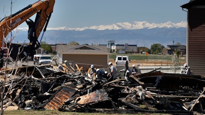 In this May 4, 2017, file photo, workers dismantle the charred remains of a house where an explosion killed two people in Firestone, Colo. A shareholder lawsuit alleges Anadarko Petroleum was focused on keeping old wells running, not fixing potential safety problems in the months before the fatal house explosion.