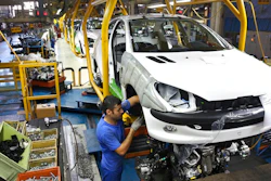 In this Oct. 11, 2014 file photo, an Iranian worker assembles a Peugeot 206 at the state-run Iran-Khodro automobile manufacturing plant near Tehran, Iran. From brand-new airplanes to oilfields, billions of dollars of deals stand on the line for international corporations as President Donald Trump weighs whether to pull America out of Iran's nuclear deal with world powers.