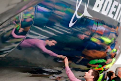 In this Feb. 5, 2018, file photo, Boeing worker Paul Covaci reaches out to touch a Boeing 737 MAX 7, the newest version of Boeing's fastest-selling airplane, during a debut for employees and media of the new jet in Renton, Wash. The U.S. withdrawal from the Iran nuclear deal means Boeing's licenses to sell billions of dollars in commercial jetliners to Iran will be revoked, Treasury Secretary Steven Mnuchin said Tuesday, May 8.