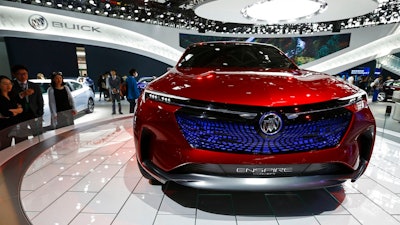 In this April 26, 2018, file photo, visitors look at a Buick Enspire concept car on display at the China Auto China in Beijing. China has announced it will reduce auto import duties effective July 1 following promises to buy more U.S. goods and end restrictions on foreign ownership in the industry. The Finance Ministry said Tuesday, May 22, 2018, that charges for many imported vehicles will be reduced from 25 percent to 15 percent.
