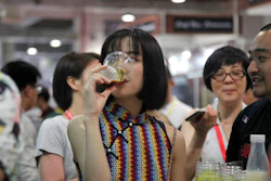 In this Thursday, May 17, 2018, photo, a woman drinks beer at the 2018 Craft Beer of China Exhibition in Shanghai. Hundreds of craft beer enthusiasts, investors and brewers are attending an exhibition in Shanghai dedicated to expanding the palette of Chinese consumers and promoting sales of high-end brews.