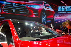 In this April 25, 2018, file photo, attendees look at the Tang SUV by Chinese automaker BYD after a press conference at the China Auto Show in Beijing. An industry group says Chinese passenger car sales expanded at a faster pace in April 2018 as growth in the world's biggest auto market picked up steam.